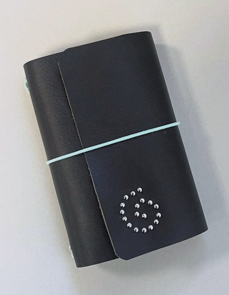 The Spiral Field Journal in black leather with mint elastic