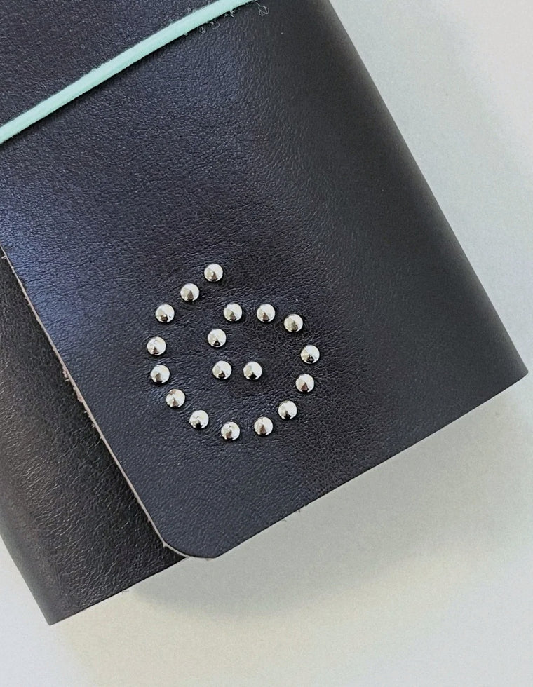 Silver eyelet spiral on the black Spiral Field Journal