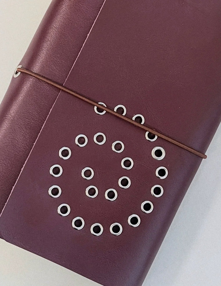 Oversized silver eyelet spiral on the oxblood A5 Spiral Journal